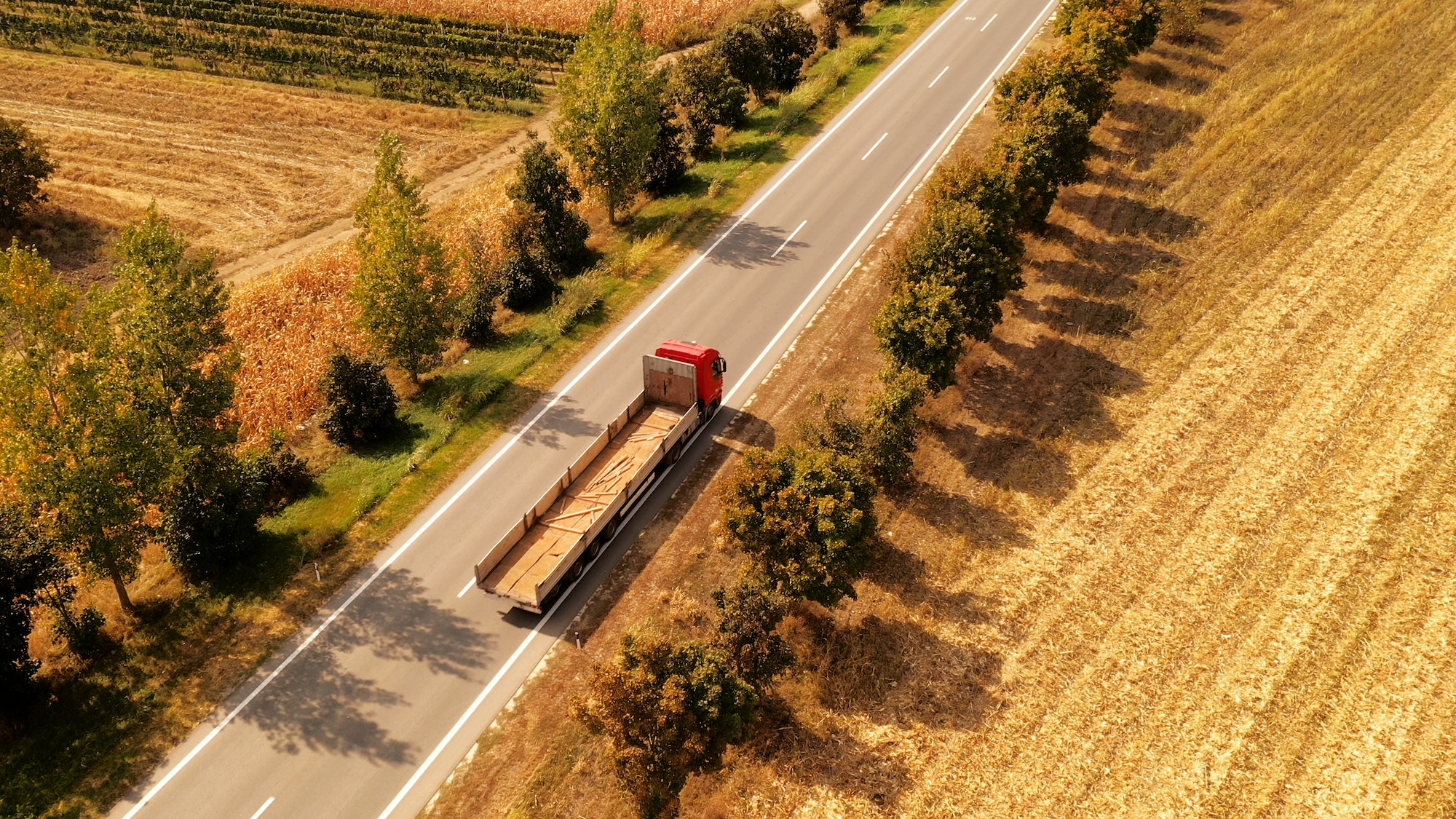 Truck on the road through countryside, aerial view